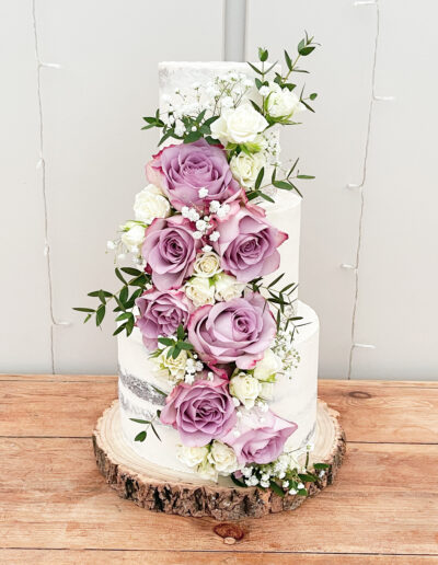 Luxury wedding cake Cornwall - Semi naked buttercream finished three tier cake dressed with fresh florals at Trevenna Barns
